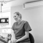 Dentist smiling confidently wearing their uniforms in a clinic.